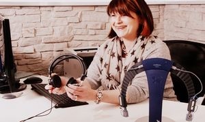 Frau im Büro mit Headset und Computer, Kundenservice und Kommunikation am Arbeitsplatz.